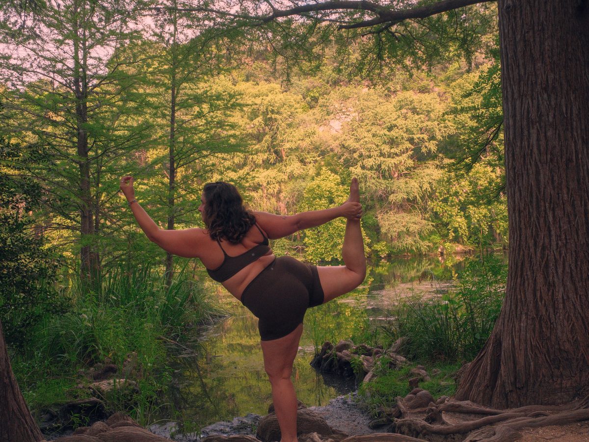 Reilley in dancer's pose beside the Austin greenbelt