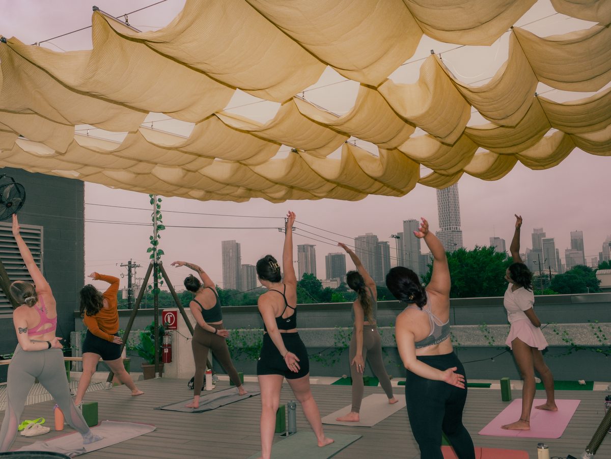Group yoga class on a downtown Austin rooftop at sunset